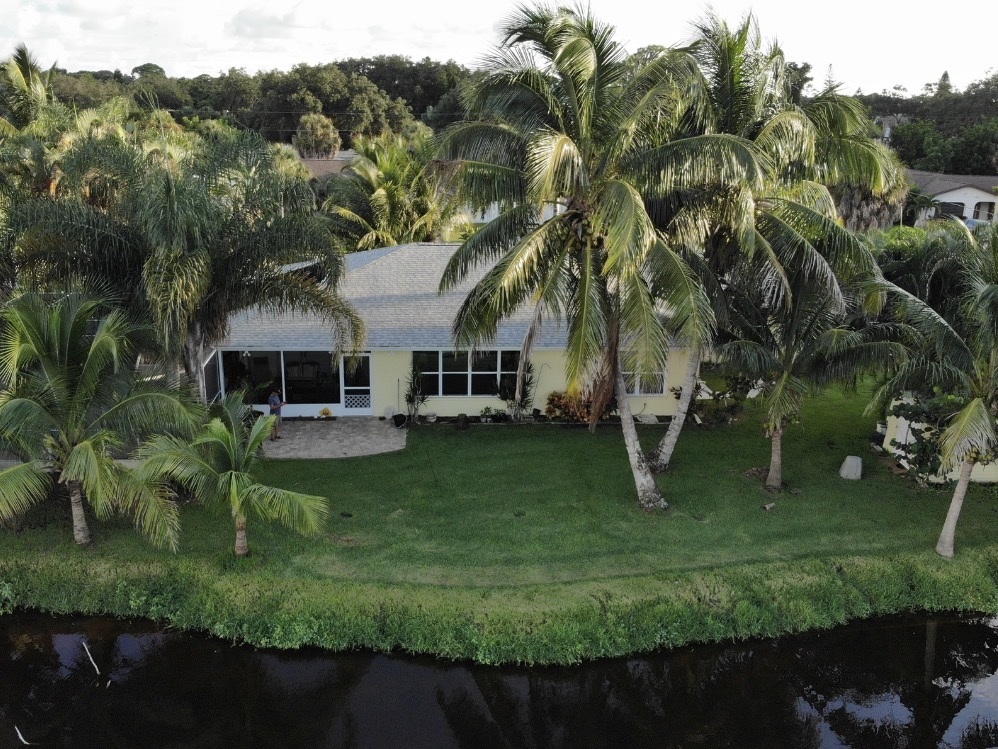 Waterfront home surrounded by palms